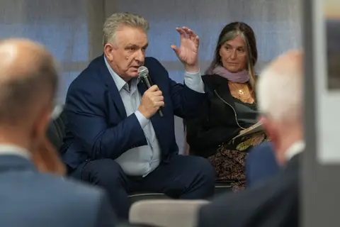 Un participante toma la palabra con el micrófono durante el diálogo empresarial.
